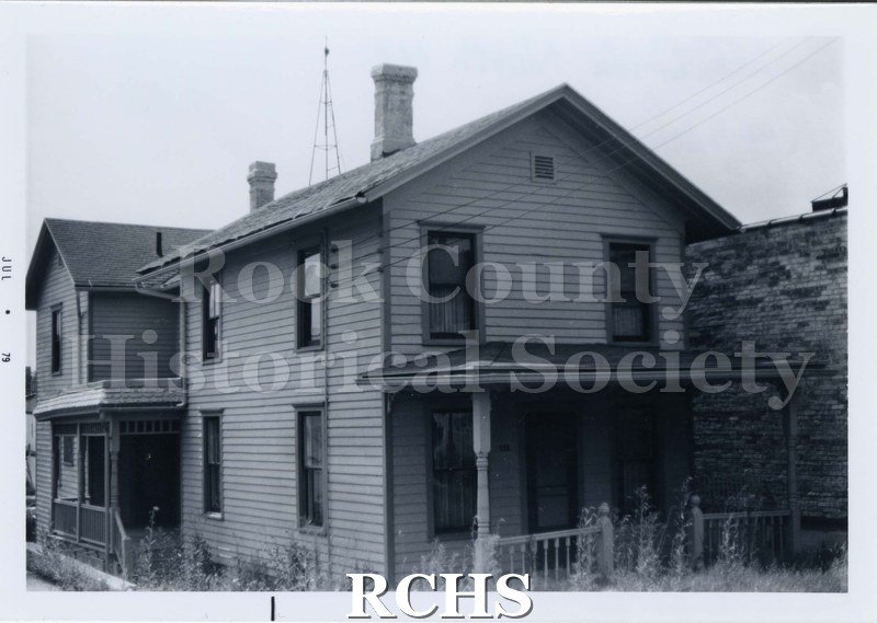 Black and white photograph of Koebler Residence, a two story wooden sided house with a porch along the front. It appears to be abandoned.