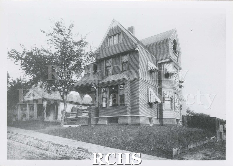 Black and white photograph of 112 St. Lawrence Avenue, a three story house with awnings on the side windows.