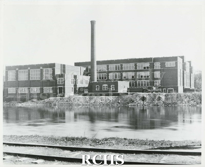 Black and white photograph of Janesville High School, including river and railroad track. Written on reverse: "Duplicate 1923 School Architectural Archive".