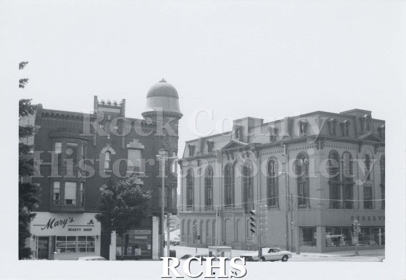 Black and white photograph of the Kent Block. Shows two buildings in downtown Janesville. The one on the left has a sign for Mary's Beauty Shop.