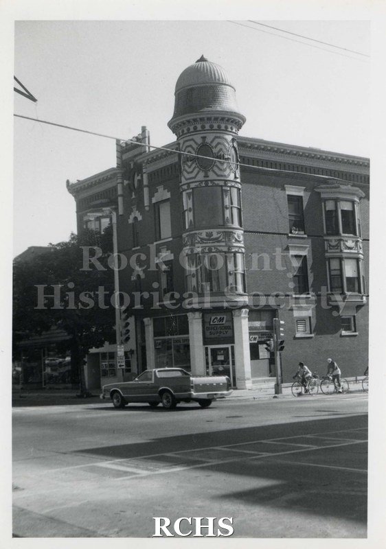 Black and white photograph of the Kent Block. Shows a building in downtown Janesville with distinctive rounded tower on the front.