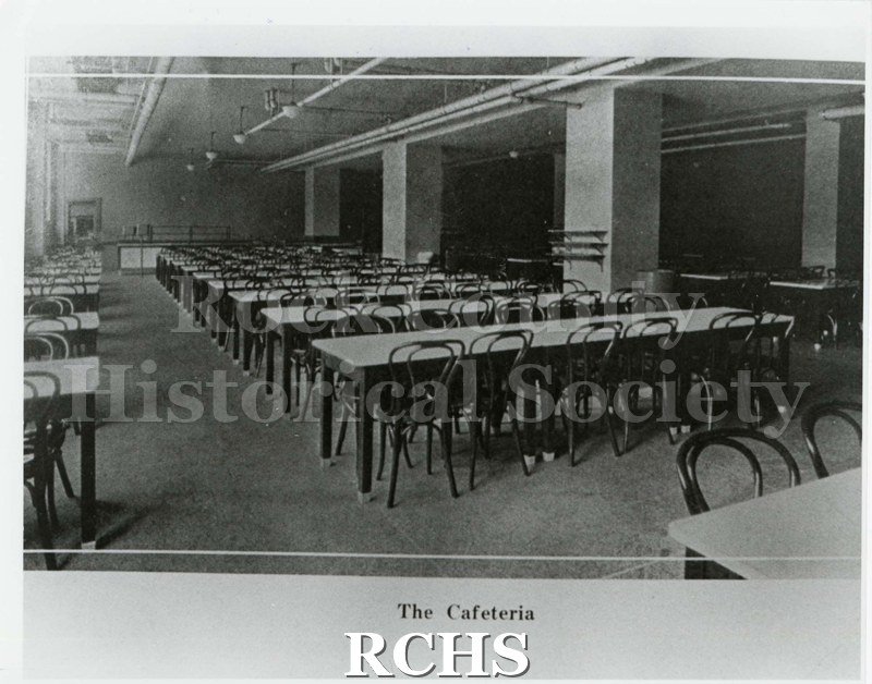 Black and white photograph of the Janesville High School cafeteria. Caption under photo: "The Cafeteria" Written on reverse: "1925 Phoenix - pg. 14".
