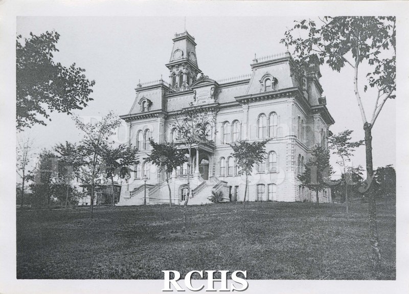 Black and white photograph of the old Court House in Janesville, showing the belltower and trees in front.