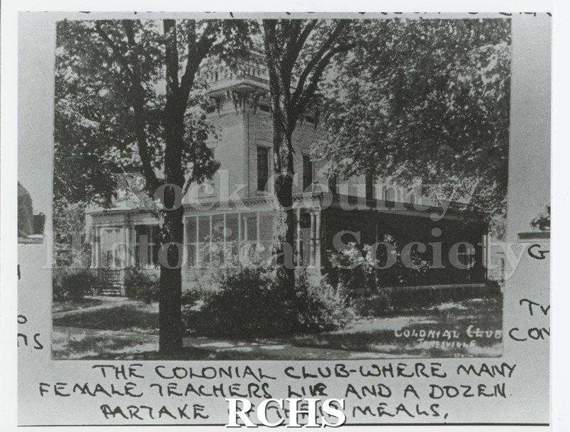 Black and white photograph of the Janesville Colonial Club teachers' residence. Shows a three story Italianate residence surrounded by a veranda.