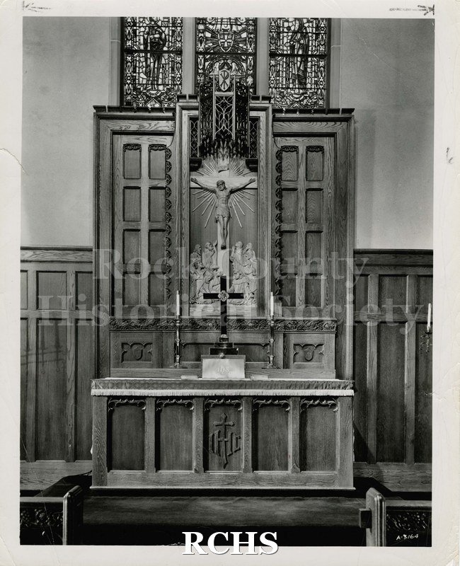 Black and white photograph of an altar made by Ossit Furniture. Altar has a candlestick on each side of the center cross.