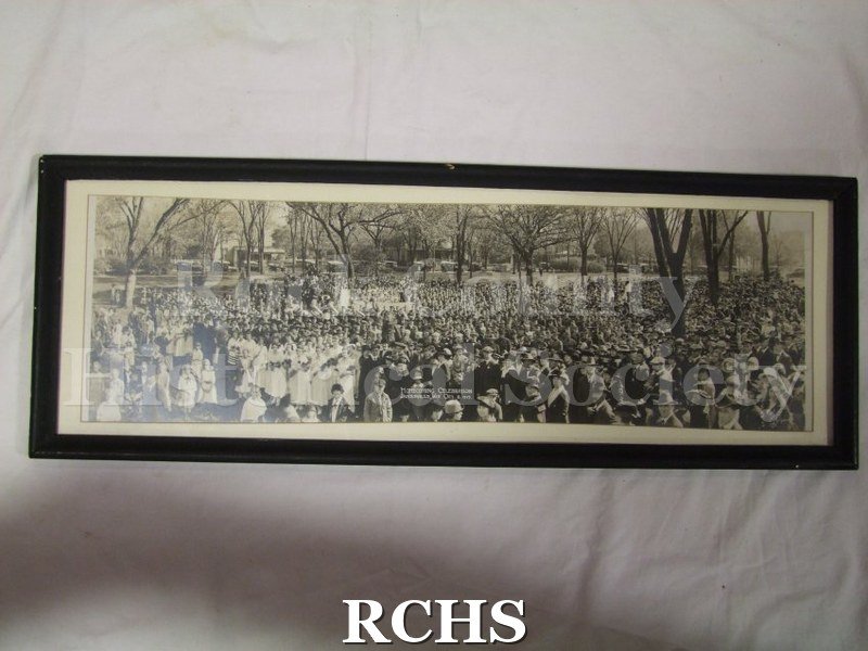Black and white photograph of Homecoming Celebration Janesville, Wis, Oct. 8, 1919. Shows a large group of people on grass in open area with trees.