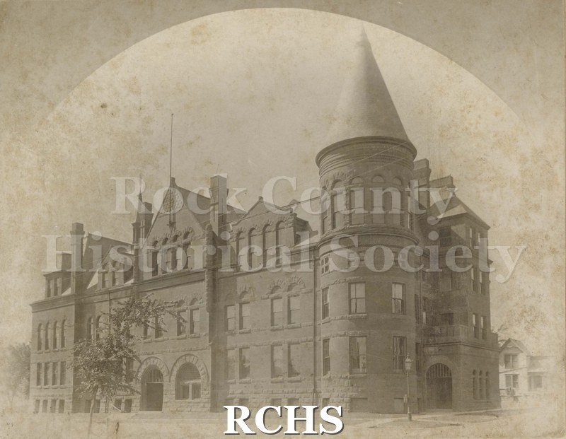 Black and white photograph of Janesville High School. Shows a three story building with a tower in front.