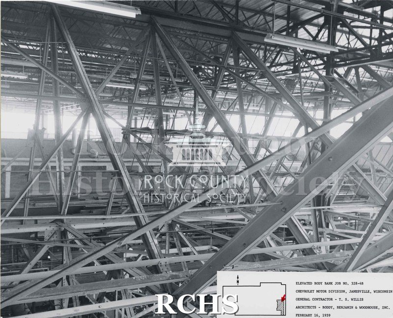 Black and white photograph of the inside girders of the factory. On bottom: "Elevated Body Bank Job No. 328-4B Chevrolet Motor Division, Janesville, Wis.