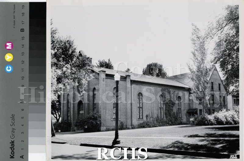 Black and white photograph of St. Peter's Lutheran Church, Janesville, WI, from the side. There are four arched stained glass windows on the right side.