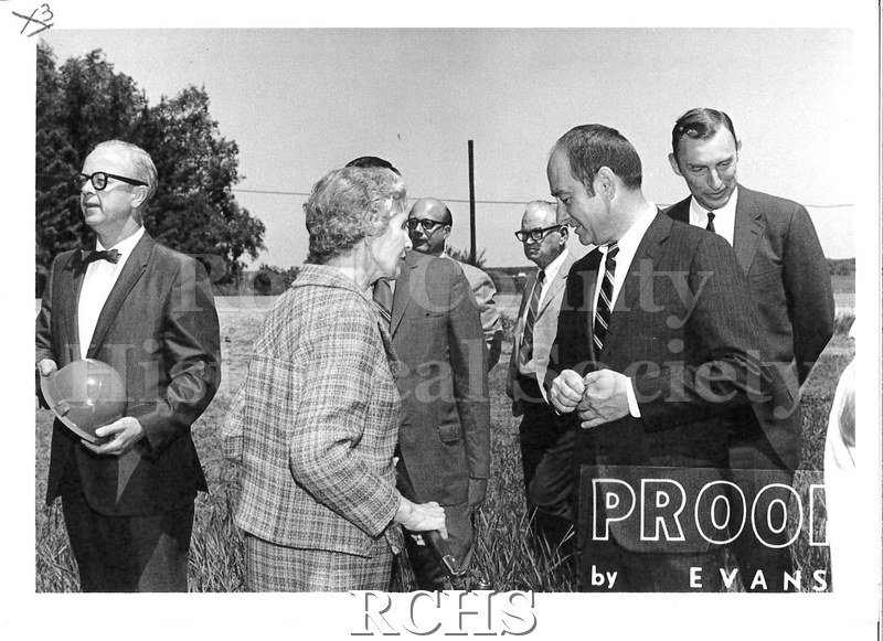 Black and white photograph of the Rock County Buick Co. Groundbreaking Ceremony. Shows 6 men and a woman at a groundbreaking ceremony.