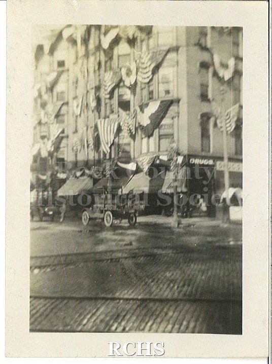 Black and white photograph of Harvest Festival Sept. 22, 1922. Shows a truck on the brick street at the corner of Main and Milwaukee Streets.