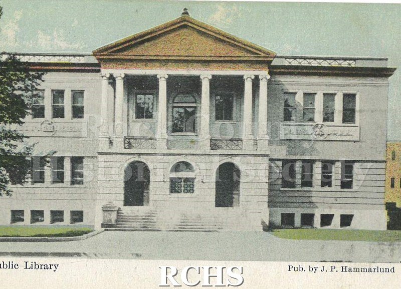 Postcard. Colored image of the Janesville Public Library. Exterior view taken from Main Street in front of the building. Published by J.P. Hammarlund.