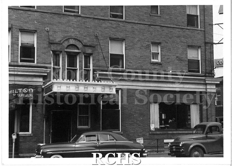Black and white photograph of Hotel Hilton, Beloit, WI. Shows the facade of a tall brick building. The building is three stories tall.