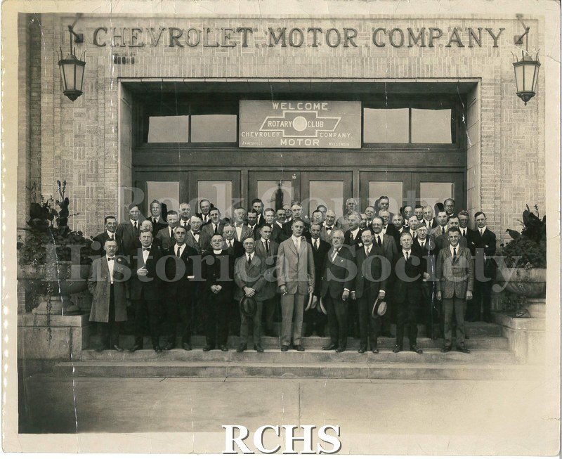 Black and white photograph of several men standing in front of the Chevrolet Motor Company.