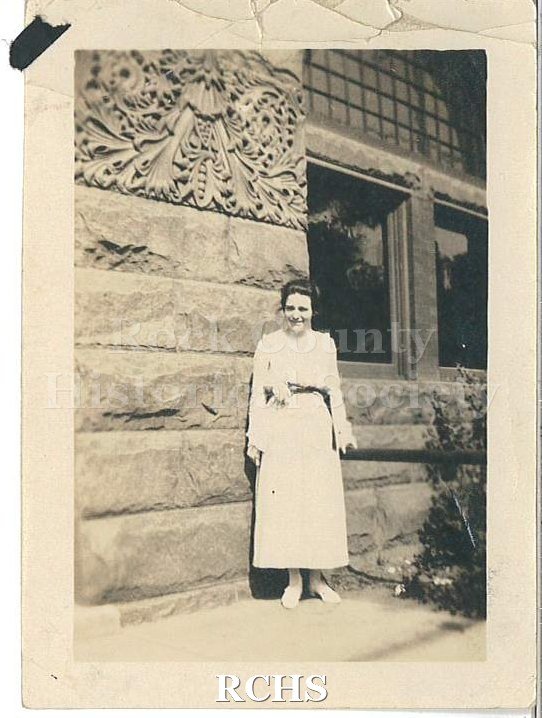 Black and white photograph of Della Hargrove standing in front of a building.