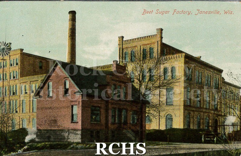 Postcard. Colorized image of the exterior of the beet sugar factory. Postcard is addressed to Mrs. Jennie Hamilton in Los Angeles. Postmarked Jan. 16, 1911.