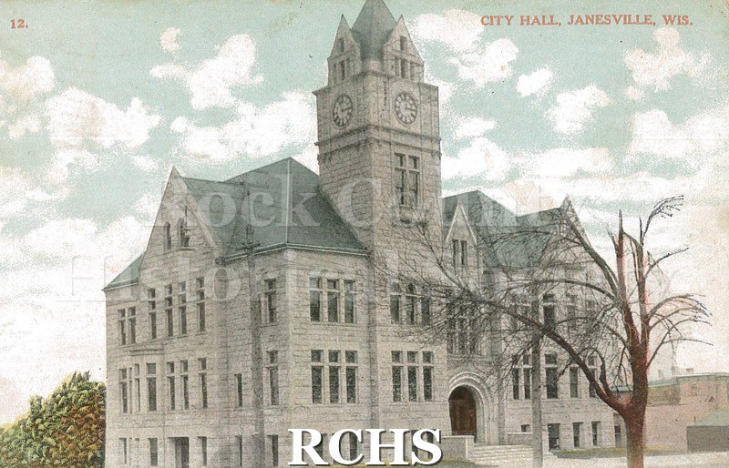 Postcard. Exterior view of the City Hall in Janesville. Postcard is addressed to Mr. Eli Buckley in Salmo, British Columbia. Postmarked Feb. 25, 1908.