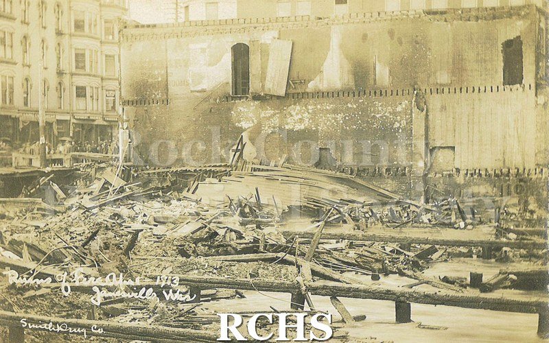 Postcard. Sepia-toned photograph of the ruins in downtown Janesville after the April 1913 fire.