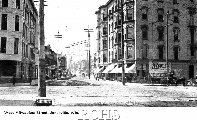 Postcard. Aluminum postcard with Black and white photograph of Milwaukee Street in Janesville. Message is not legible.