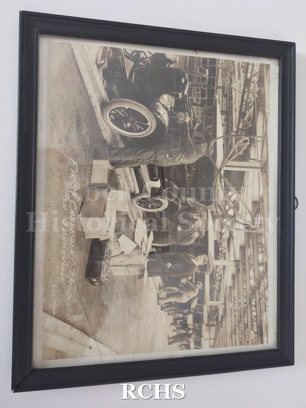Black and white photograph of GM plant workers on the line finishing the first Chevrolet to be produced in Janesville. Photo was taken in August 1923.