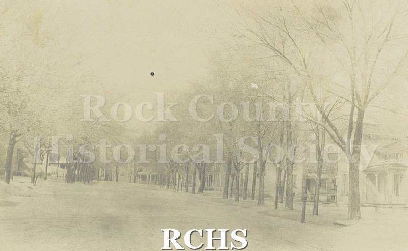Postcard. Black and white photograph of High Street in Janesville. Addressed to Mrs. B.F. Dunwiddie of Janesville. Postmarked 24 June 1908.