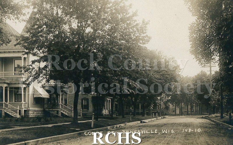 Postcard. Black and white photograph of E. Court Street in Janesville.