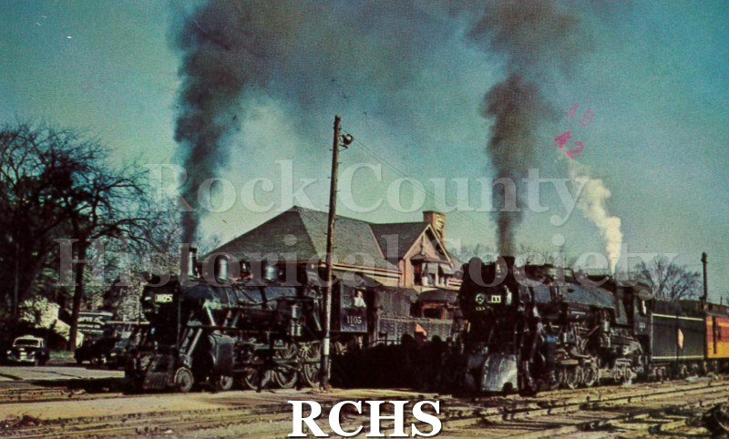 Postcard. color photo of Milwaukee Road engines at the Janesville depot in 1950. Addressed to Ida Hartung of Janesville. Postmarked 1 September 1978.