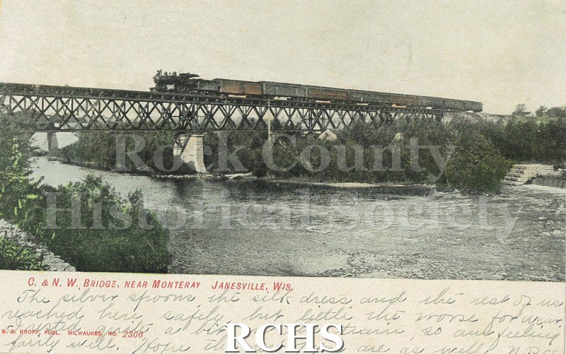 Postcard. Tinted image of a train on a Chicago & Northwestern Railroad bridge near Monterey in Janesville. Addressed to Mrs. L.C. Burdick of Milton.