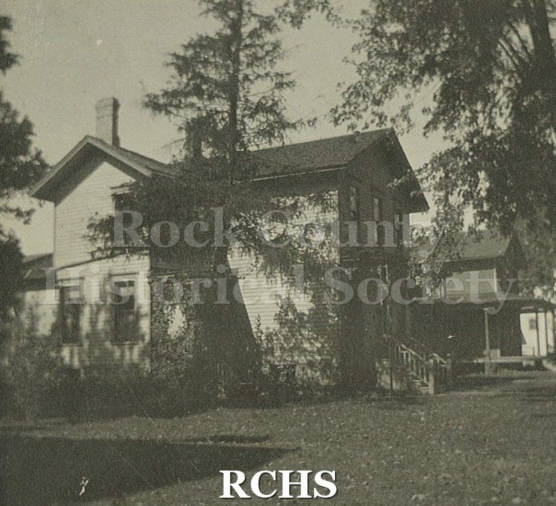 Black and white photograph of the house of Mr. & Mrs. J. R. Botsford, Janesville, WI. Shows a two story house with trees around it.