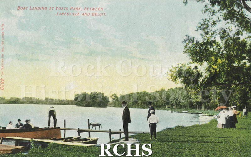 Postcard. Tinted image of individuals at the boat landing at Yosts Park between Janesville and Beloit. Postcard is addressed to Mrs. F.M. Jones in Bangor, Maine.