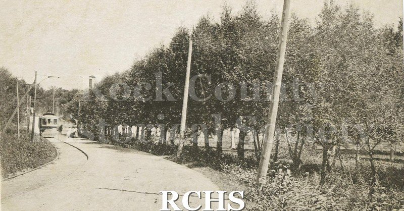 Postcard. Black and white photograph of the trolley running near Spring Brook in Janesville.