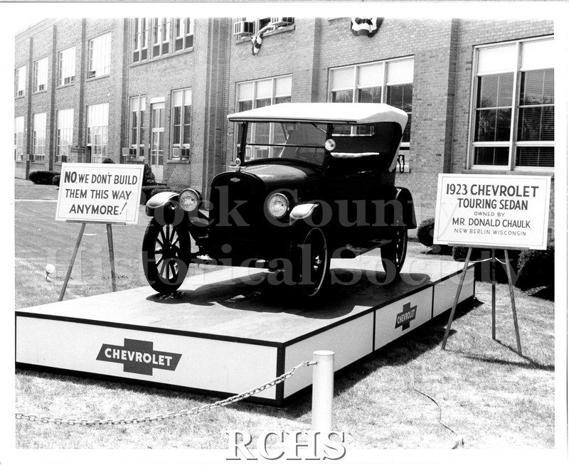 Black and white photograph of a 1923 Chevrolet Touring Sedan on display outside of the Janesville GM plant as part of the celebrations for the 100 millionth GM car.