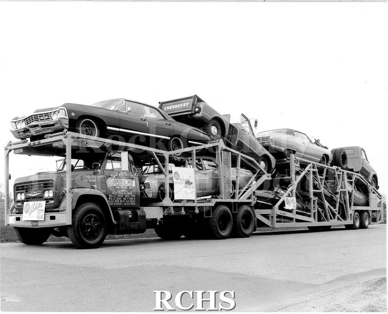 Black and white photograph of a fully loaded JATCO transport trailer and cab. Cab is number 605; painted on the hood.