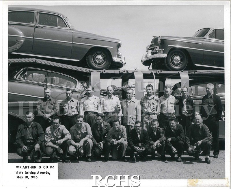 Black and white group photo of W. R. Arthur & Co. (later JATCO) drivers. There are two rows of men. The back row is standing, the front row is kneeling.
