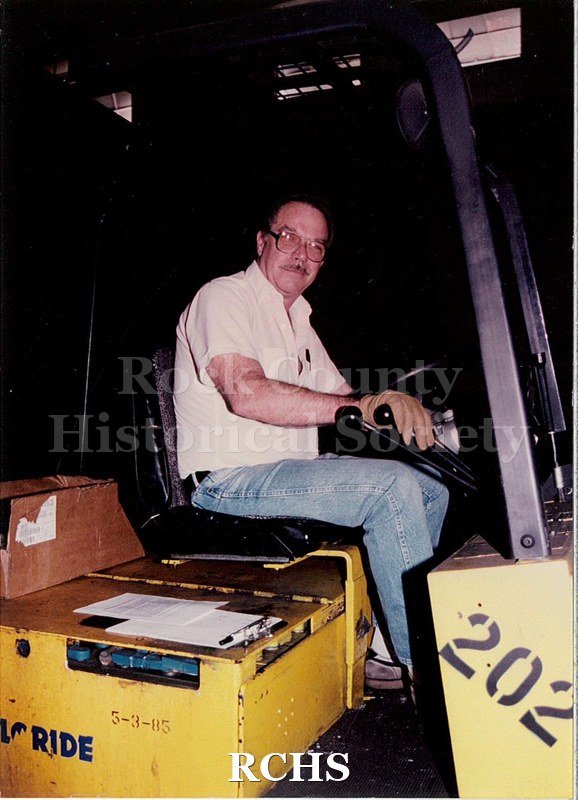 Color photo with flash of a man, Larry Schwartzlow, working at Janesville General Motors.