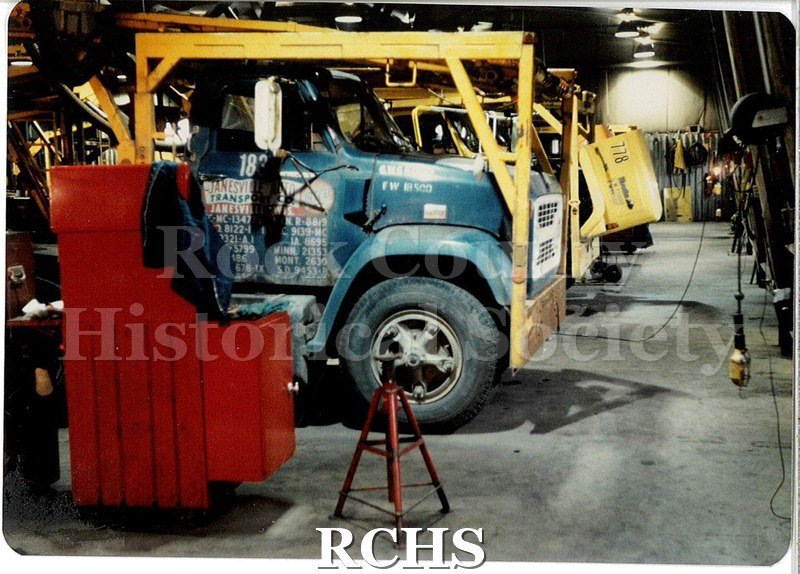 Color photo of the minor repair bay at JATCO (Janesville Auto Transport Co.) Cabs for car transport trailers are lined up in the repair bay.