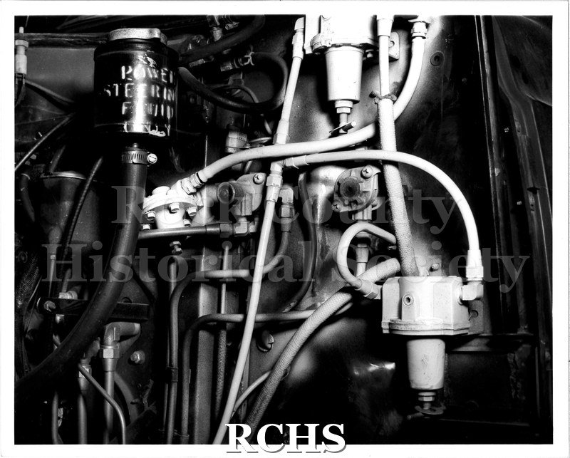 Black and white photograph of the power steering mechanism in an old truck cab.