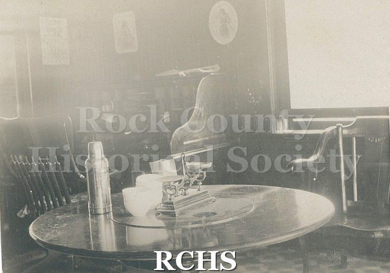 Postcard. Black and white image of an office inside the Janesville Wholesale Grocery, which was located at 202 N. High Street. The office belonged to Mr.