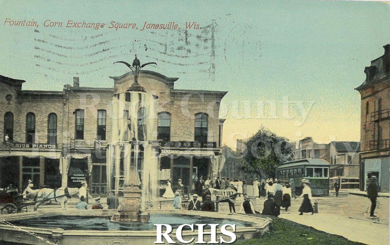 Postcard. Tinted image of the fountain at the Corn Exchange in Janesville. Postmarked 24 April 1911 and addressed to Mrs. John Maerzke of Watertown.