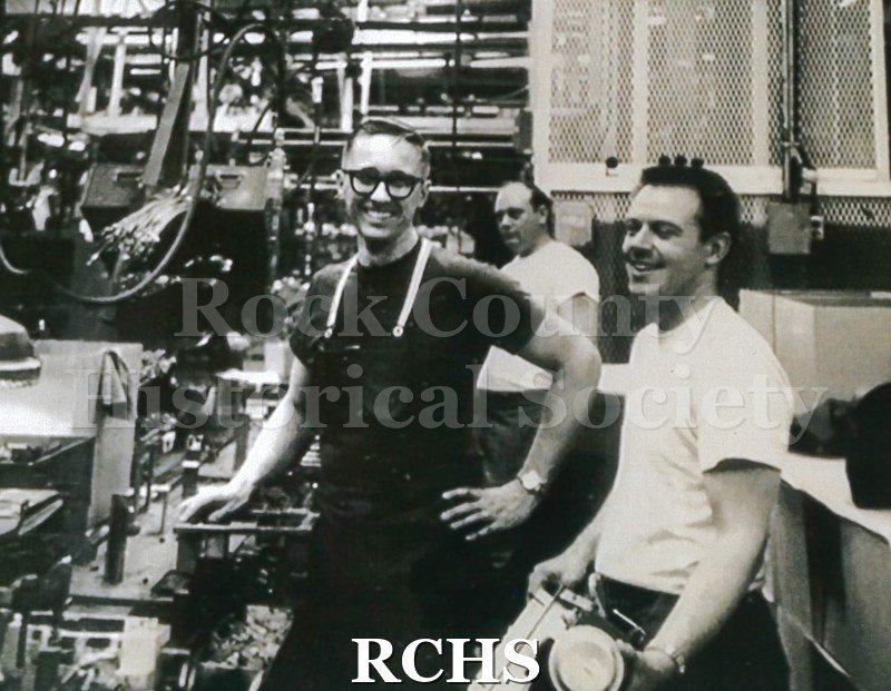 Black and white photograph of Jerry Kleinert (left) on the heater line at the GM plant with Orville Smith. Kleinert worked at GM from 1965-1997.