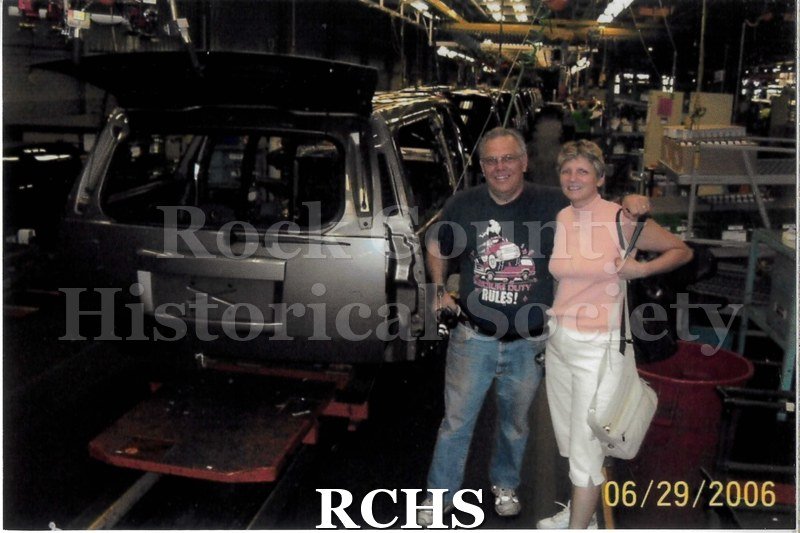 Digital color photo of two people posing together on the line at Janesville General Motors.