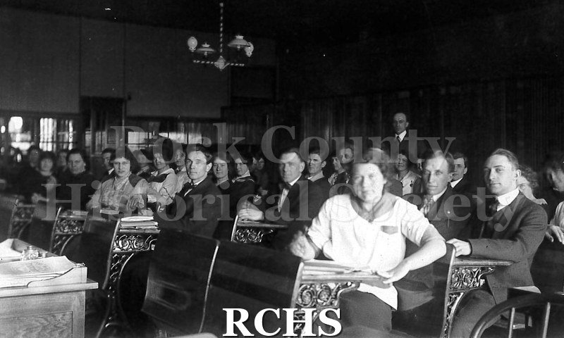 Postcard. Students on a postcard. Shows several adult students sitting at desks.