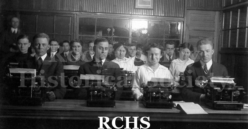 Postcard. Students on a postcard. Shows several adult students sitting in front of typewriters.