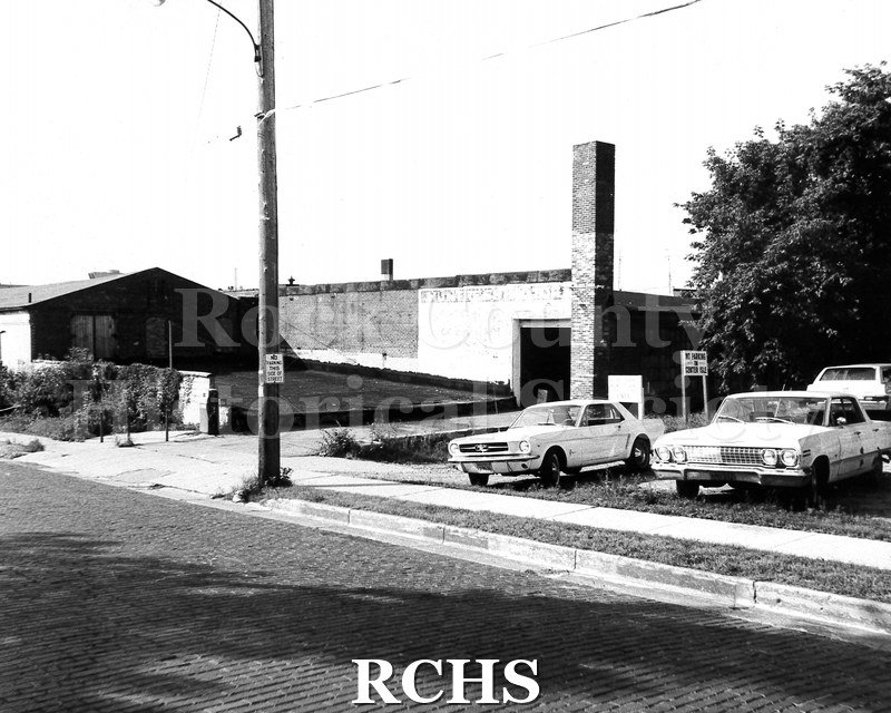 Black and white photograph of Huntress Motors, Division Street. Shows a flat roofed building with "Huntress Motors" sign on top.