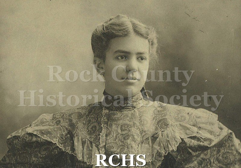 Black and white photograph of May Felton as a young woman. Medium color hair with center part, pulled back.