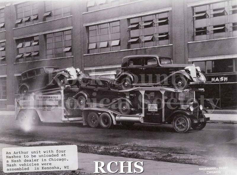 Black and white photograph of a W.R. Arthur transporter loaded with four Nash automobiles to be unloaded at a Chicago dealer.