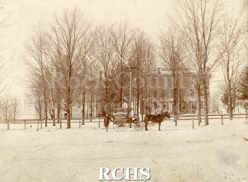 Black and white photograph of Evansville Seminary. Shows a three story building with trees in front of it and snow on the ground.