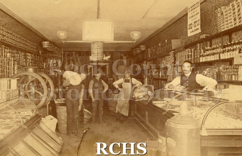 Black and white photograph of Jones' Grocery Store with four men standing in it.