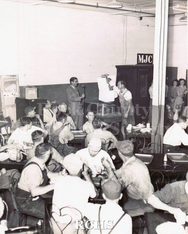 Black and white portrait of Clarence Dittmer receiving a portable radio for his entry into the GM "My Job and Why I Like It" corporate competition in 1947.