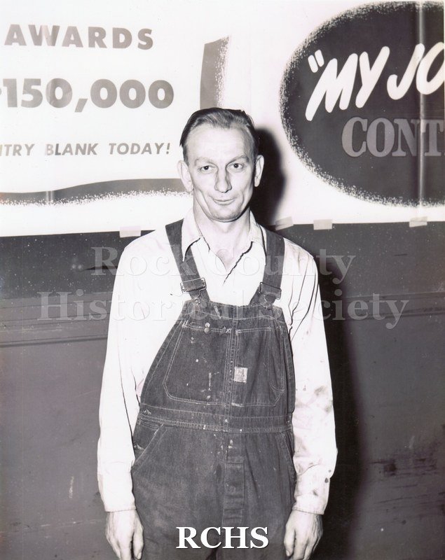Black and white portrait of Clarence Dittmer receiving a portable radio for his entry into the GM "My Job and Why I Like It" corporate competition in 1947.